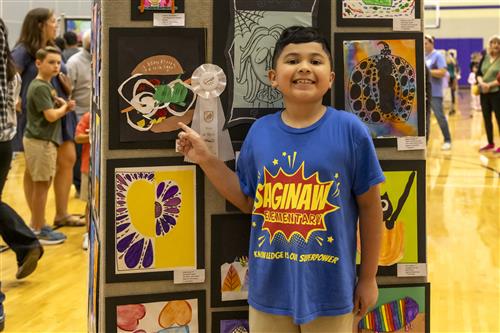 Elementary student with their artwork